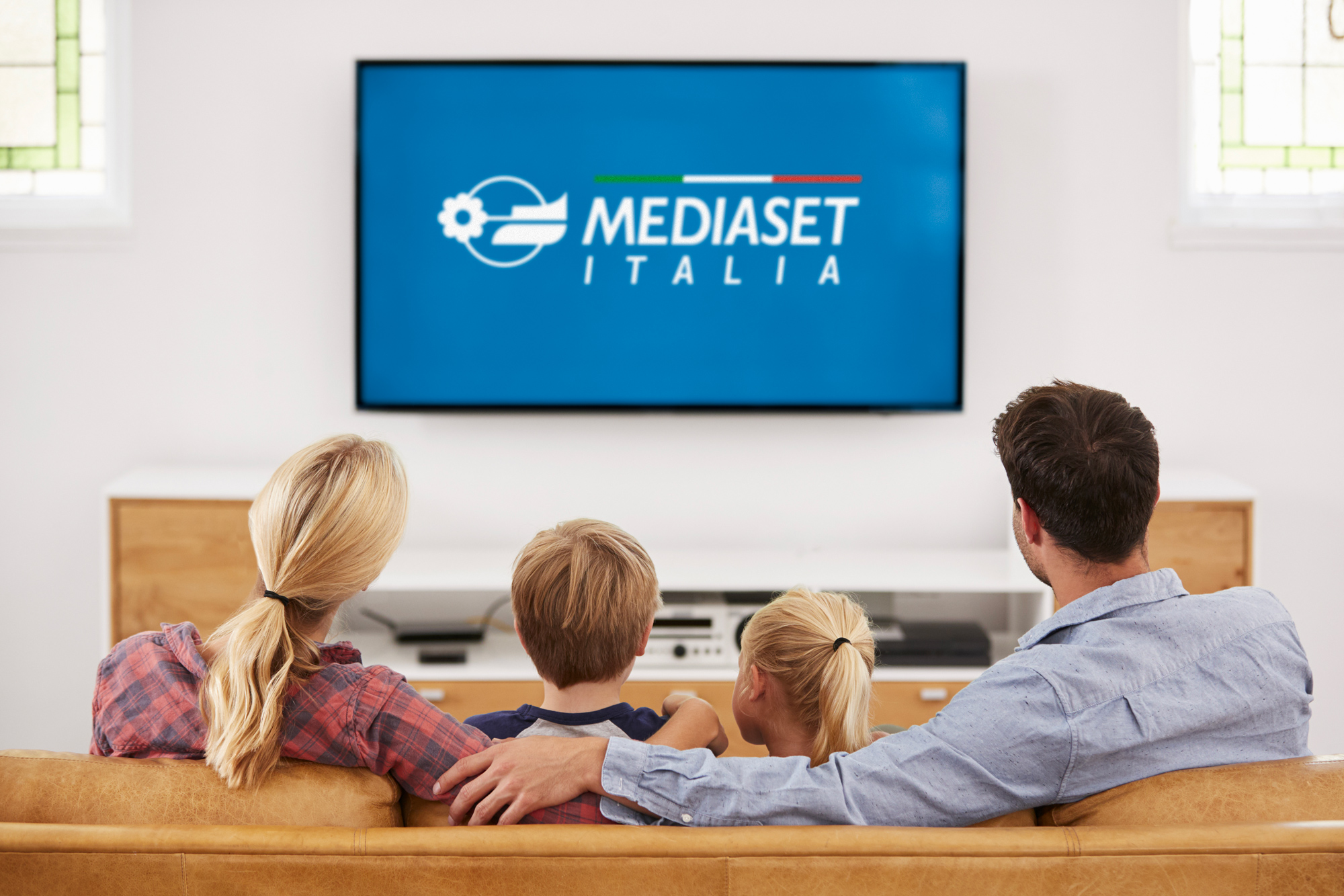 Family watching Italian content on TV in a cozy living room